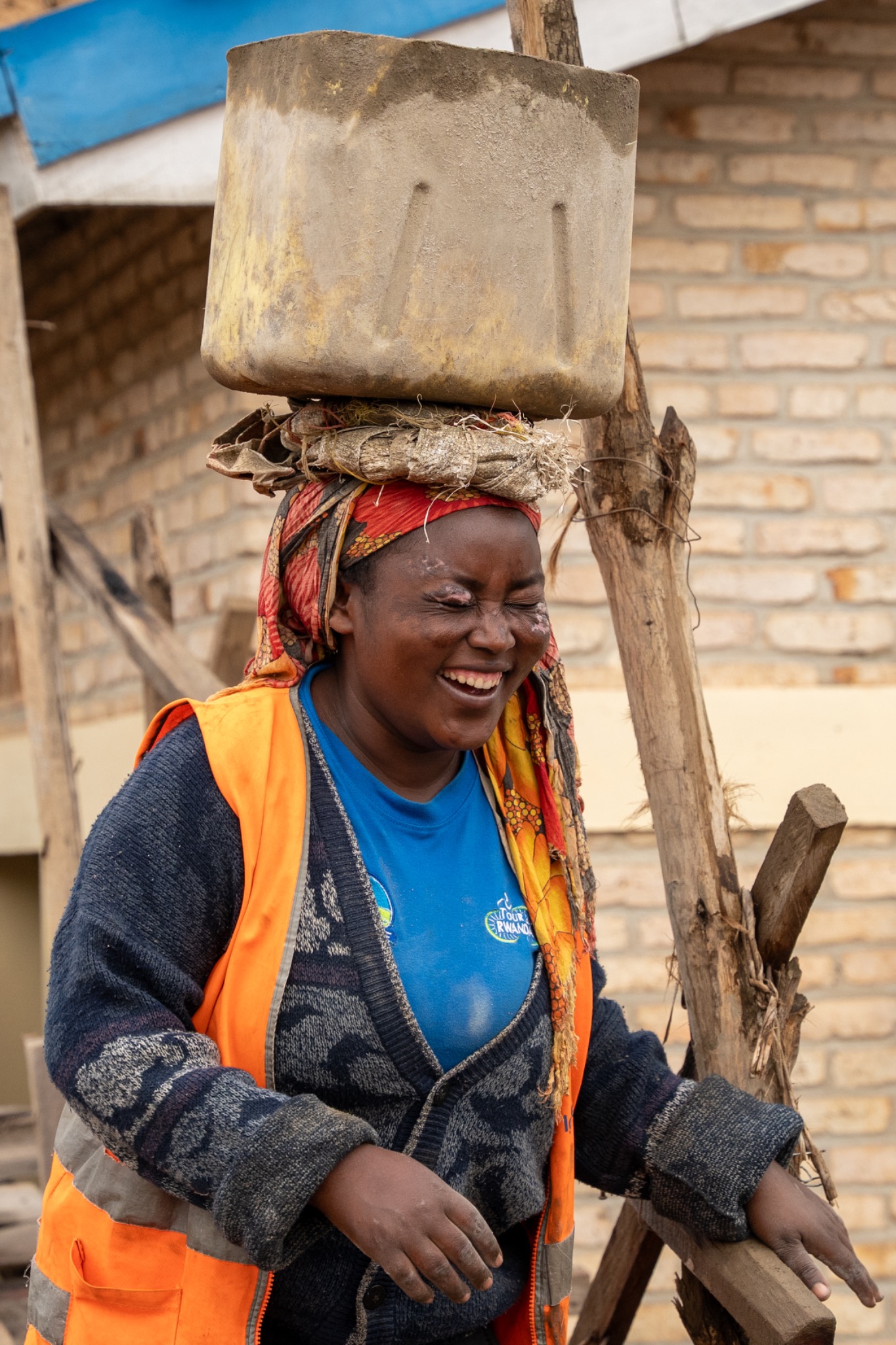 A woman laughing while working in her community in Rwanda